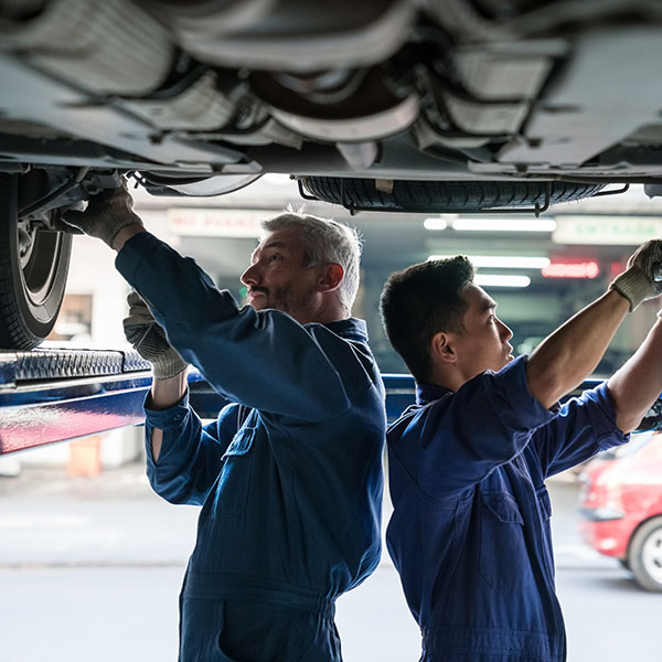Car mechanics checking vehicle chassis
